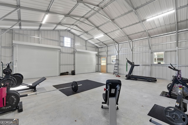 exercise area featuring a garage, metal wall, and vaulted ceiling