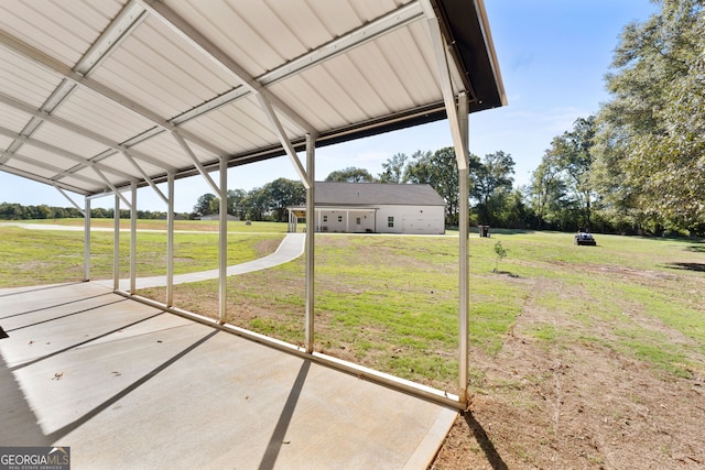 view of green lawn with a patio and a carport