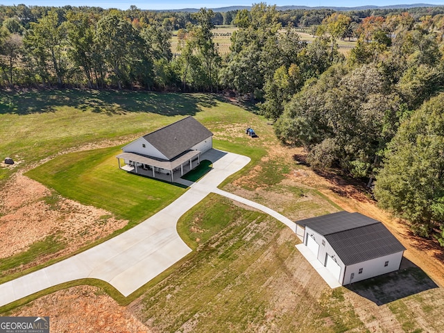 aerial view of property and surrounding area with a heavily wooded area