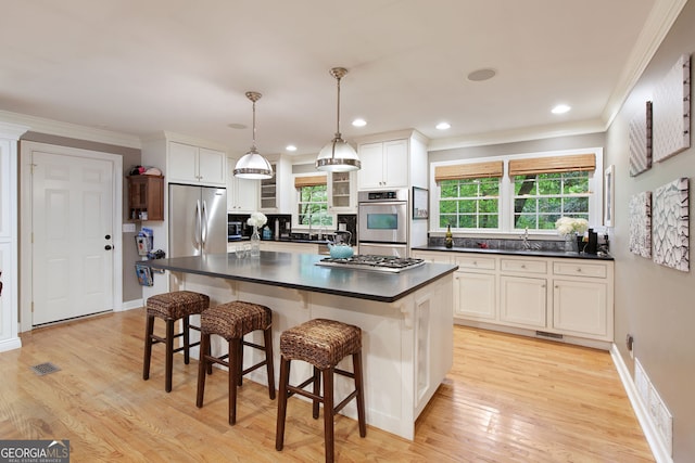 220 N Springs Ct, Sandy Springs, GA 30328 - kitchen with dark countertops, stainless steel appliances, crown molding, white cabinets, and light wood-type flooring
