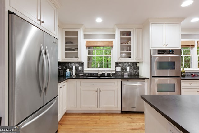 220 N Springs Ct, Sandy Springs, GA 30328 - kitchen featuring appliances with stainless steel finishes, dark countertops, crown molding, healthy amount of natural light, and decorative backsplash