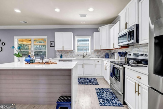 2102 Braswell Ln, Loganville, GA 30052 - kitchen featuring stainless steel appliances, a sink, crown molding, white cabinetry, and recessed lighting