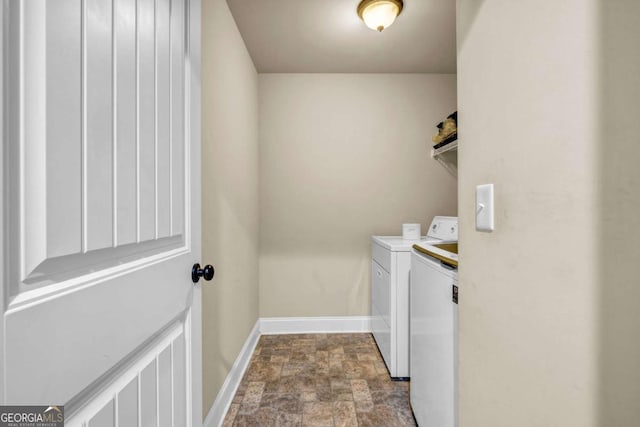 2102 Braswell Ln, Loganville, GA 30052 - laundry room with washing machine and clothes dryer, baseboards, and stone finish floors