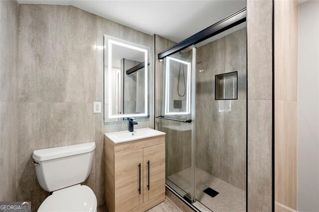 2828 Cloverhurst, Atlanta, GA 30344 - bathroom featuring a shower stall, toilet, vanity, and tile walls