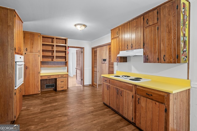 kitchen featuring white appliances, under cabinet range hood, open shelves, dark wood finished floors, and brown cabinetry