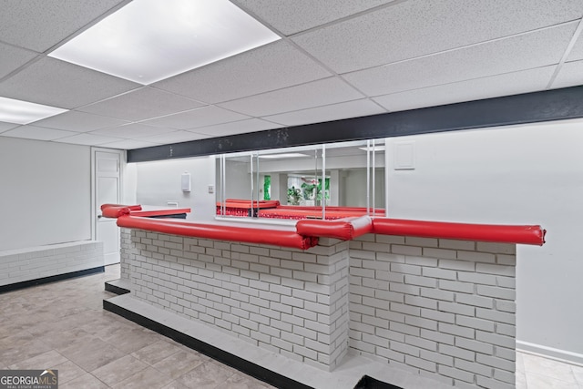 bar area with tile patterned flooring and a drop ceiling