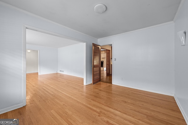 unfurnished room featuring light wood-type flooring, crown molding, and baseboards