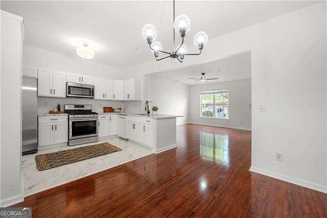 1135 Kilmington Ct, Alpharetta, GA 30009 - kitchen featuring appliances with stainless steel finishes, a chandelier, open floor plan, light wood-style floors, and a sink
