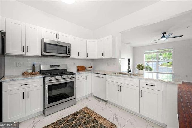 1135 Kilmington Ct, Alpharetta, GA 30009 - kitchen featuring stainless steel appliances, a sink, a peninsula, white cabinets, and light marble finish flooring