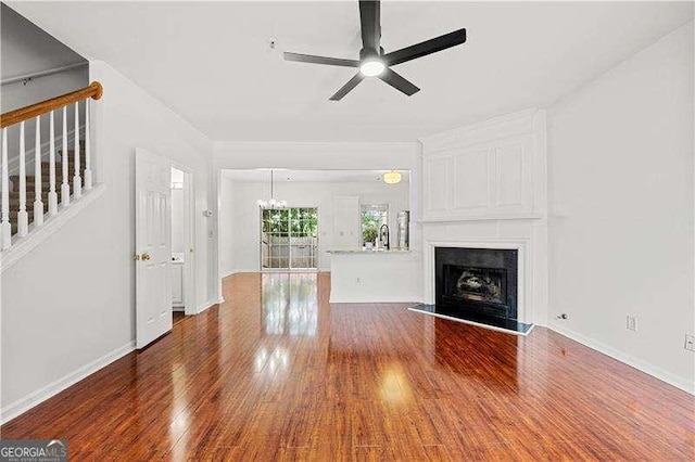 1135 Kilmington Ct, Alpharetta, GA 30009 - unfurnished living room featuring wood finished floors, a ceiling fan, a large fireplace, baseboards, and stairway
