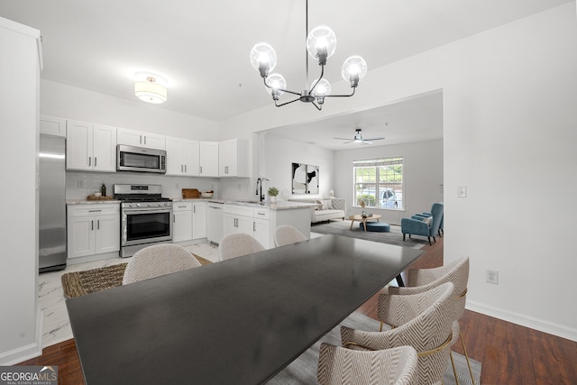 1135 Kilmington Ct, Alpharetta, GA 30009 - kitchen featuring appliances with stainless steel finishes, a chandelier, a sink, open floor plan, and white cabinetry