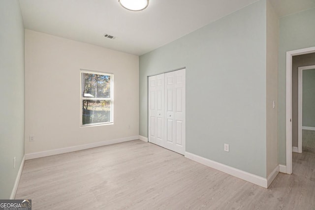 7428 Mockingbird Trl, Riverdale, GA 30274 - unfurnished bedroom featuring light wood-type flooring, baseboards, and a closet