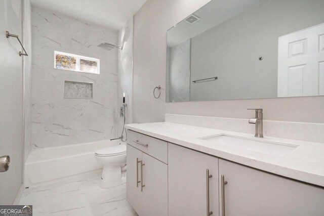 7428 Mockingbird Trl, Riverdale, GA 30274 - bathroom featuring toilet, marble look tile flooring, vanity, and bathtub / shower combination