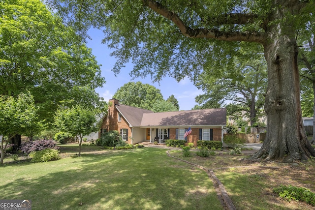503 Bonnie Dr, Woodstock, GA 30188 - view of front facade with a front yard, a chimney, and brick siding