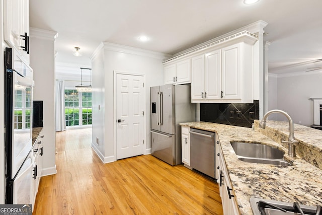 610 Golden Meadows Ln, Suwanee, GA 30024 - kitchen featuring stainless steel appliances, a sink, crown molding, white cabinetry, and decorative backsplash