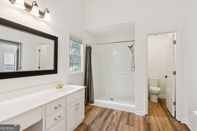 610 Golden Meadows Ln, Suwanee, GA 30024 - bathroom featuring toilet, wood finished floors, vanity, and tiled shower
