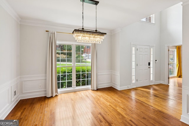 610 Golden Meadows Ln, Suwanee, GA 30024 - unfurnished dining area with a chandelier, hardwood / wood-style floors, and ornamental molding