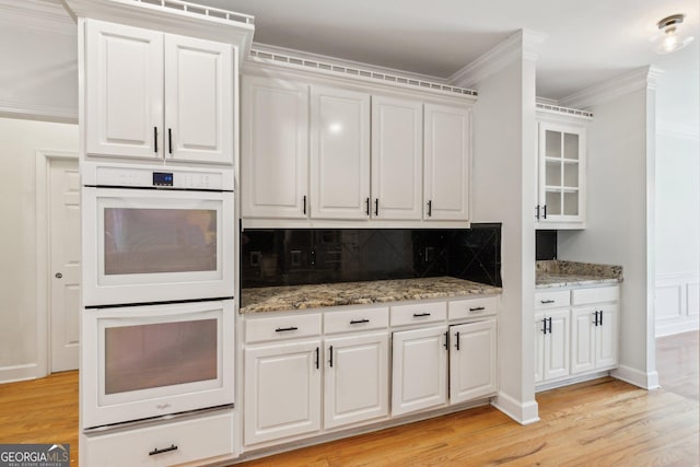 610 Golden Meadows Ln, Suwanee, GA 30024 - kitchen featuring double oven, light wood-type flooring, backsplash, white cabinetry, and crown molding