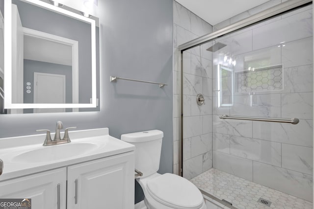 full bathroom featuring a stall shower, toilet, and vanity
