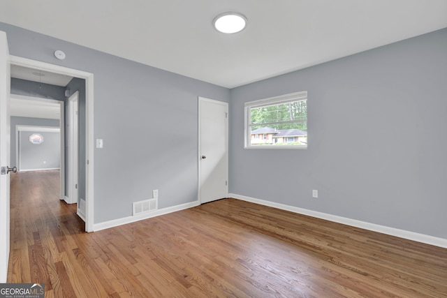 unfurnished bedroom featuring wood finished floors and baseboards