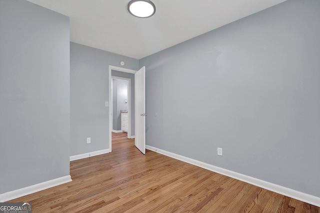 spare room featuring baseboards and light wood finished floors