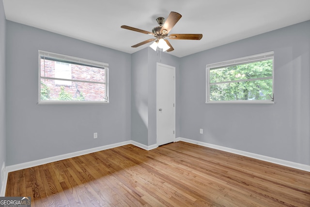 spare room featuring baseboards, light wood finished floors, and ceiling fan