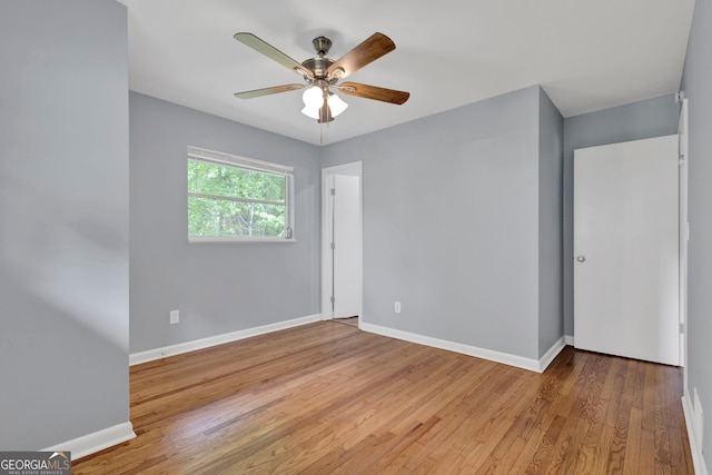 empty room with baseboards, wood finished floors, and ceiling fan