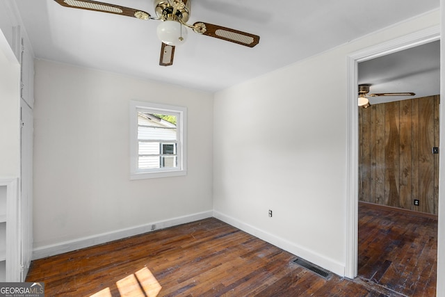 empty room featuring ceiling fan, dark wood-style floors, and baseboards