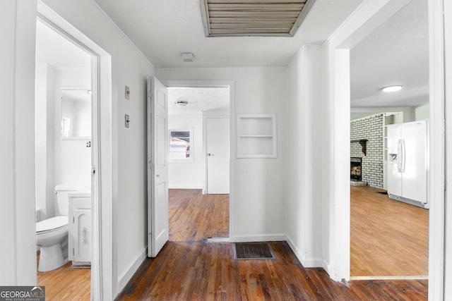 corridor featuring wood finished floors and baseboards