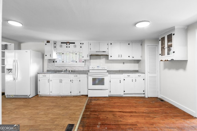 kitchen featuring white appliances, under cabinet range hood, a sink, and white cabinetry