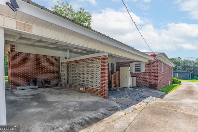 view of side of home with brick siding, a carport, and crawl space