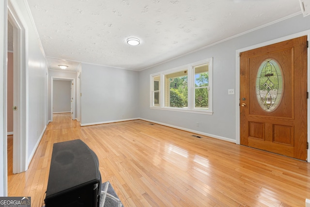 entrance foyer with crown molding, healthy amount of natural light, light wood finished floors, and baseboards