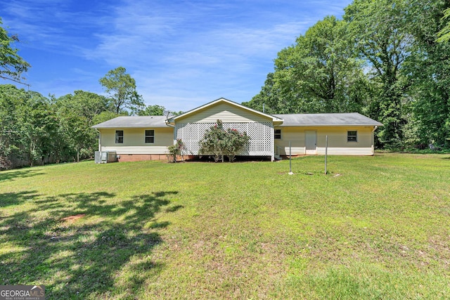 back of property featuring a lawn and central AC unit
