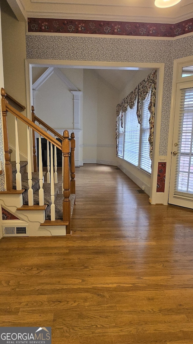 unfurnished living room featuring wood finished floors, stairs, and plenty of natural light