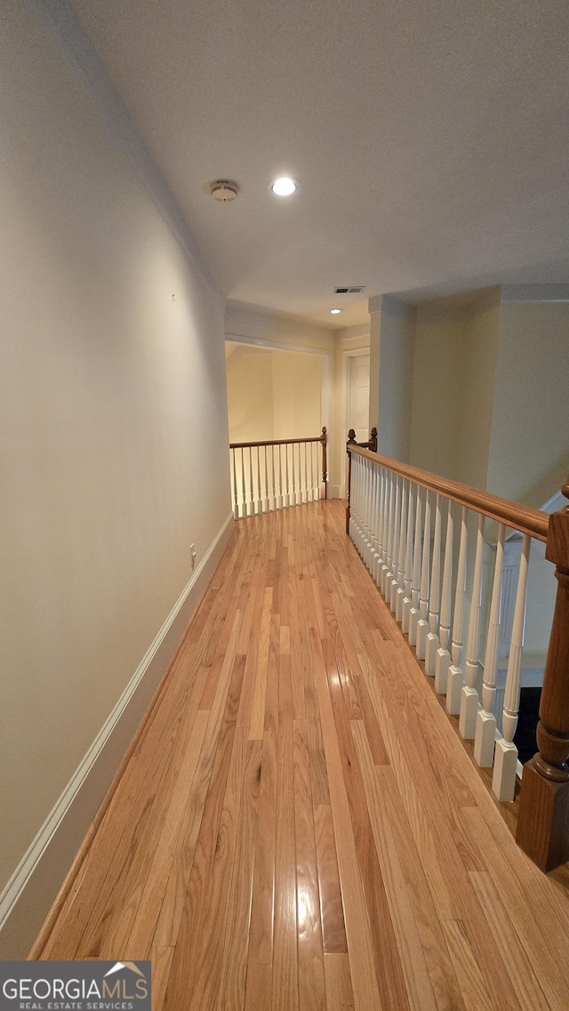 hallway with wood finished floors, baseboards, and recessed lighting