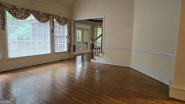 spare room featuring wood finished floors, french doors, vaulted ceiling, stairway, and baseboards