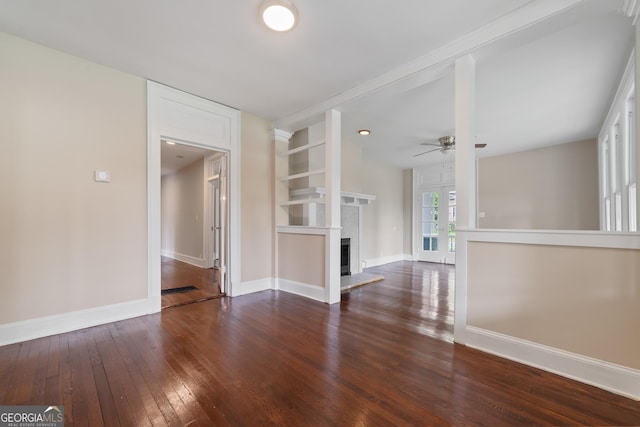 409 N Jefferson Ave, Eatonton, GA 31024 - unfurnished living room with hardwood / wood-style floors, ceiling fan, a fireplace with raised hearth, baseboards, and built in shelves