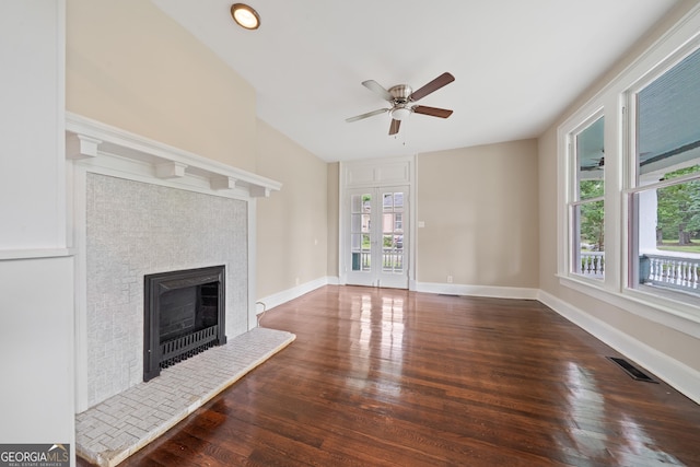 409 N Jefferson Ave, Eatonton, GA 31024 - unfurnished living room with wood finished floors, a tile fireplace, a ceiling fan, and baseboards