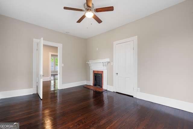 409 N Jefferson Ave, Eatonton, GA 31024 - unfurnished living room with wood finished floors, a tiled fireplace, a ceiling fan, and baseboards
