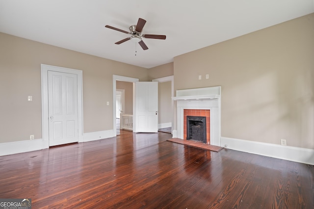 409 N Jefferson Ave, Eatonton, GA 31024 - unfurnished living room with wood finished floors, ceiling fan, a tile fireplace, and baseboards