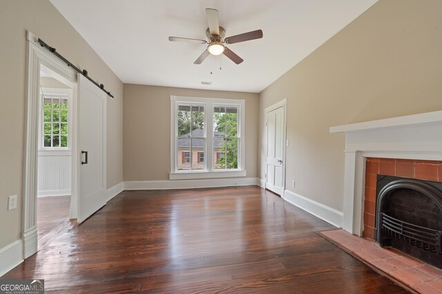 409 N Jefferson Ave, Eatonton, GA 31024 - unfurnished living room featuring a barn door, healthy amount of natural light, and wood finished floors