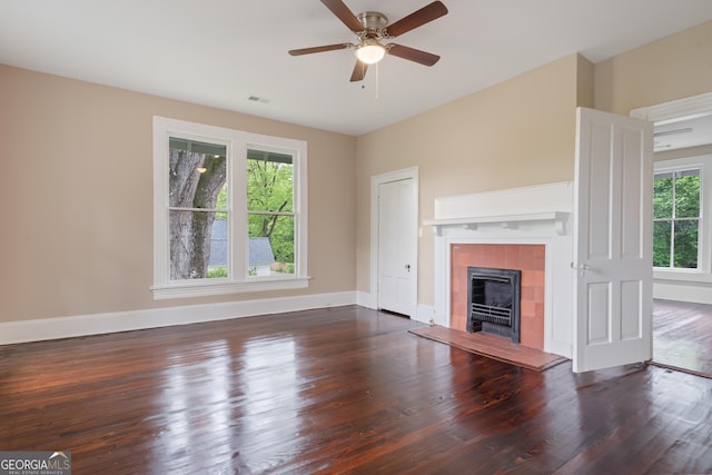 409 N Jefferson Ave, Eatonton, GA 31024 - unfurnished living room featuring wood finished floors, ceiling fan, a tile fireplace, and baseboards