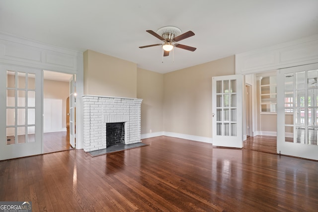 409 N Jefferson Ave, Eatonton, GA 31024 - unfurnished living room featuring a ceiling fan, wood finished floors, a brick fireplace, and french doors