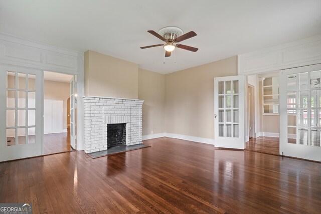 409 N Jefferson Ave, Eatonton, GA 31024 - unfurnished living room featuring a ceiling fan, wood finished floors, a fireplace, and french doors
