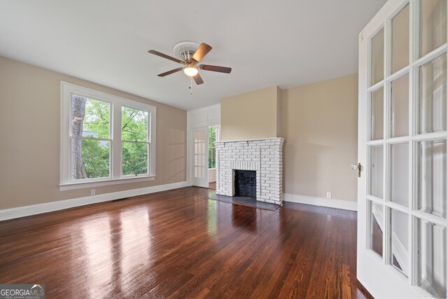 409 N Jefferson Ave, Eatonton, GA 31024 - unfurnished living room with ceiling fan, wood finished floors, a fireplace, and baseboards