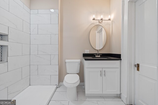 409 N Jefferson Ave, Eatonton, GA 31024 - bathroom with marble look tile flooring, toilet, vanity, a tile shower, and baseboards