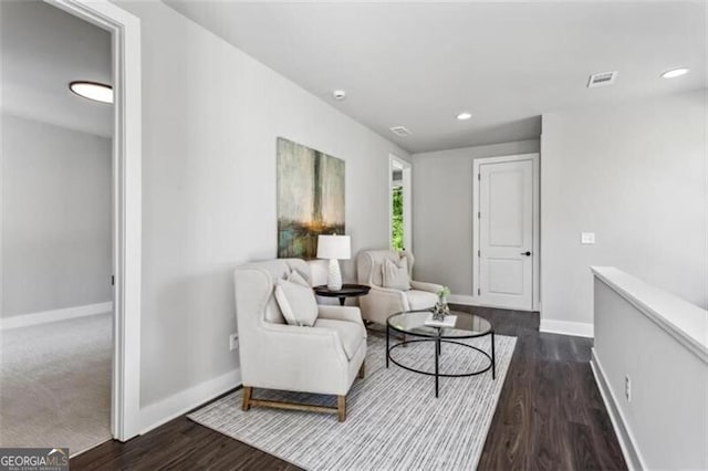 living area with baseboards, dark wood-type flooring, and recessed lighting
