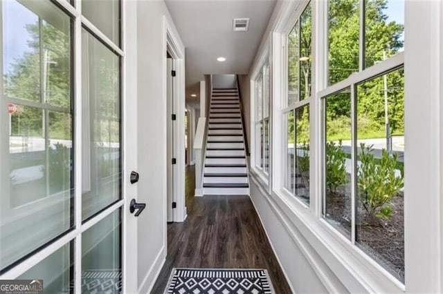 corridor featuring dark wood-style floors, baseboards, plenty of natural light, and recessed lighting