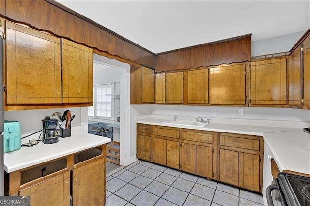 104 Dellwood Dr NW, Rome, GA 30165 - kitchen with a sink, electric range, light tile patterned floors, brown cabinetry, and light countertops