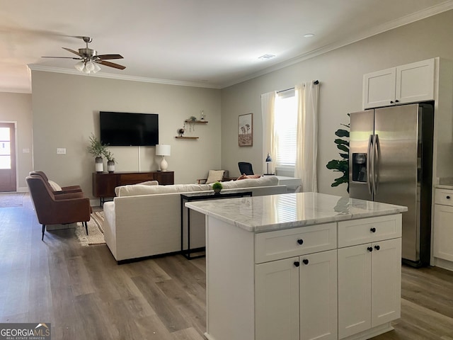 3812 Hartley Bridge Rd, Macon, GA 31216 - kitchen featuring stainless steel fridge, ornamental molding, plenty of natural light, white cabinetry, and wood finished floors